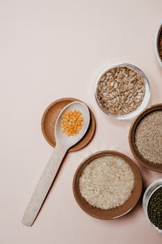 Healthy dog enjoying a bowl of cooked amaranth grains with vegetables and a water bowl nearby.