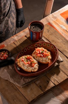 A dog curiously sniffing a plate of refried beans, illustrating the topic of beans in a dog's diet.